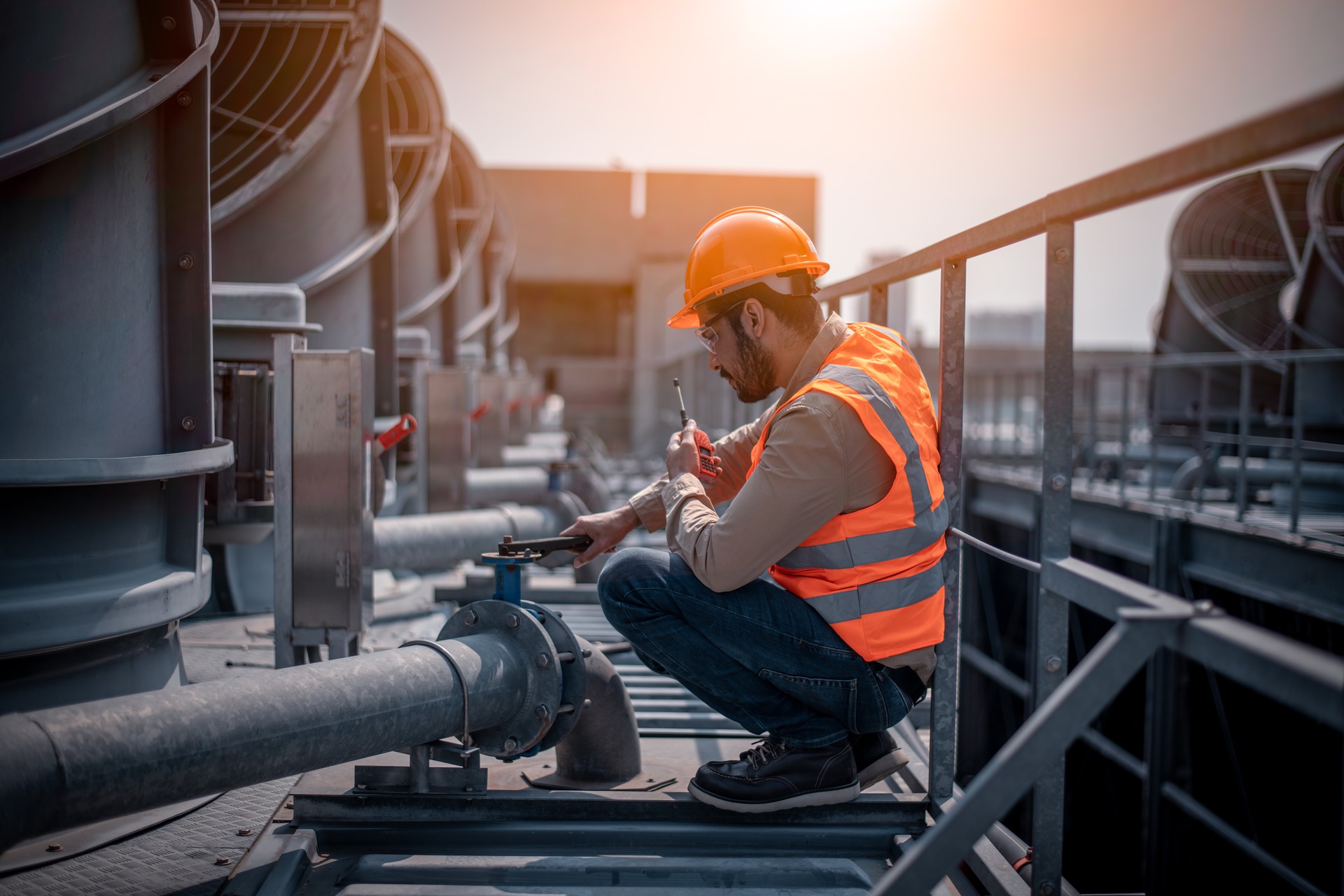 Industry engineer under checking the industry cooling tower air conditioner is water cooling tower air chiller HVAC of large industrial building to control air system.